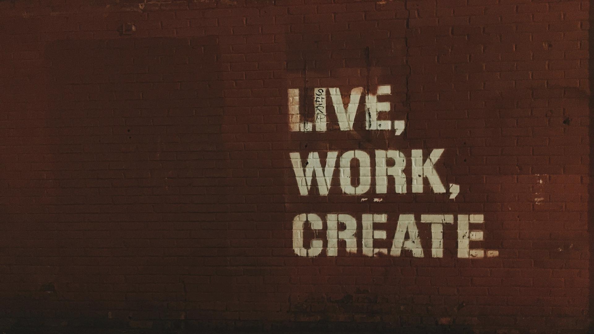 red brick wall with live, work, create. quote